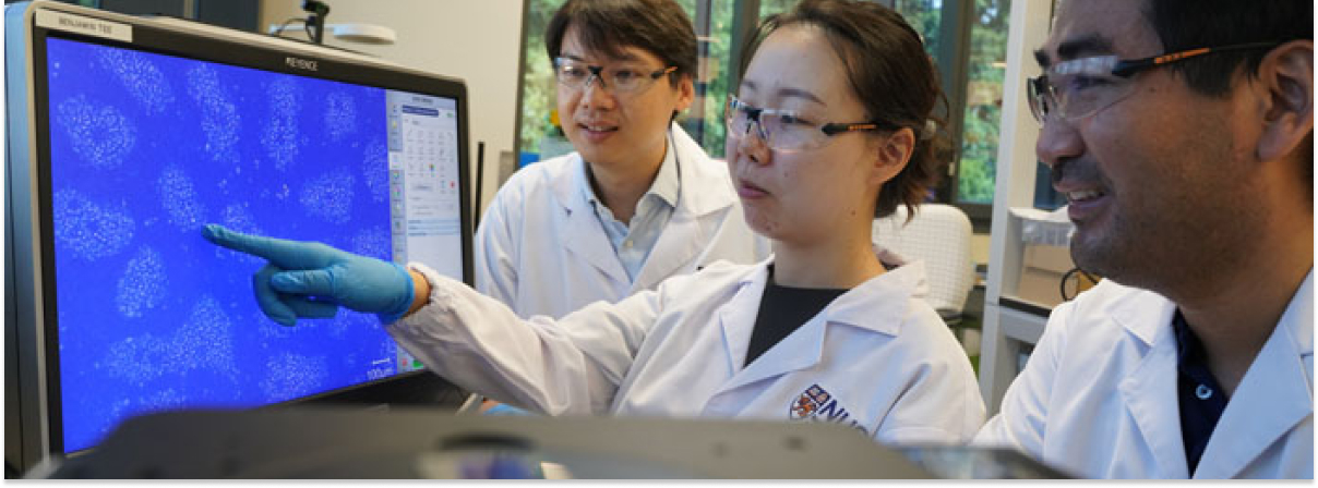 Tres científicos observan datos de sensores en un laboratorio con pantalla azul