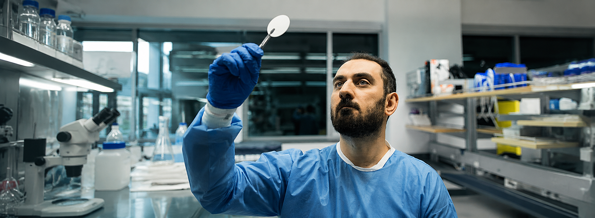 Investigador examina una membrana de filtración en laboratorio para eliminar nanoplásticos de lixiviado de vertedero